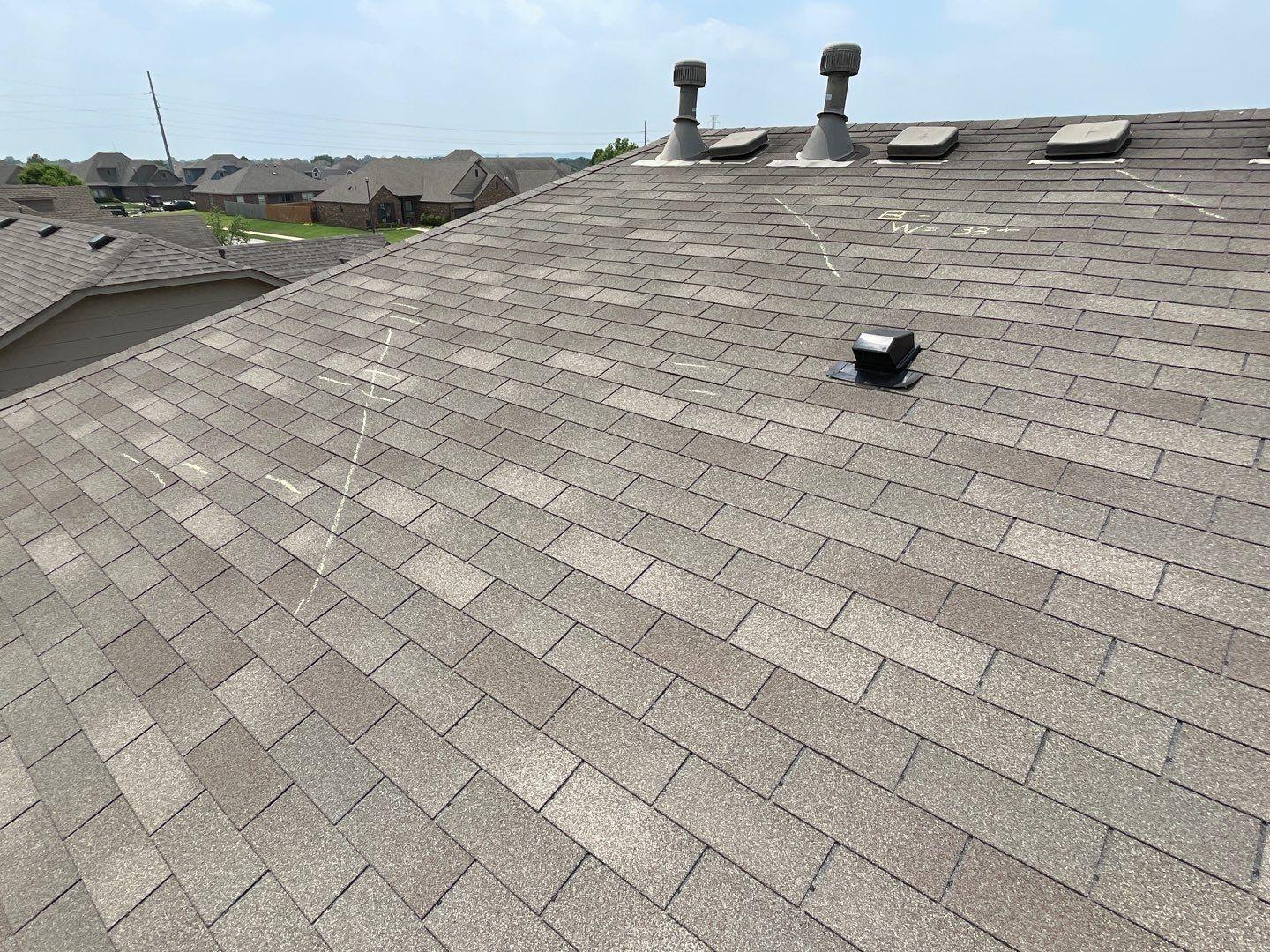 Hail damage marked with chalk during a roof inspection