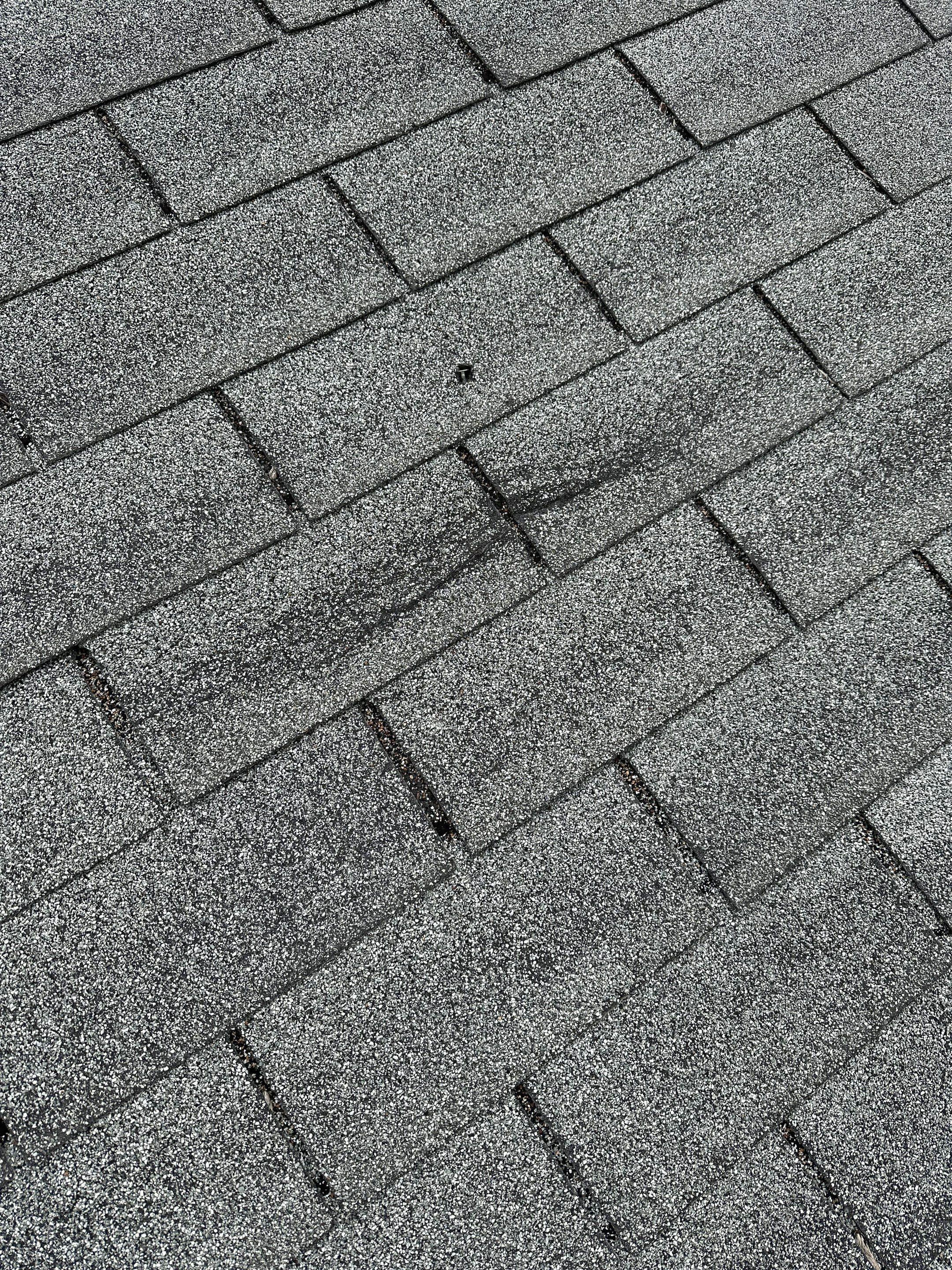 Wind and hail damage on an asphalt shingle roof